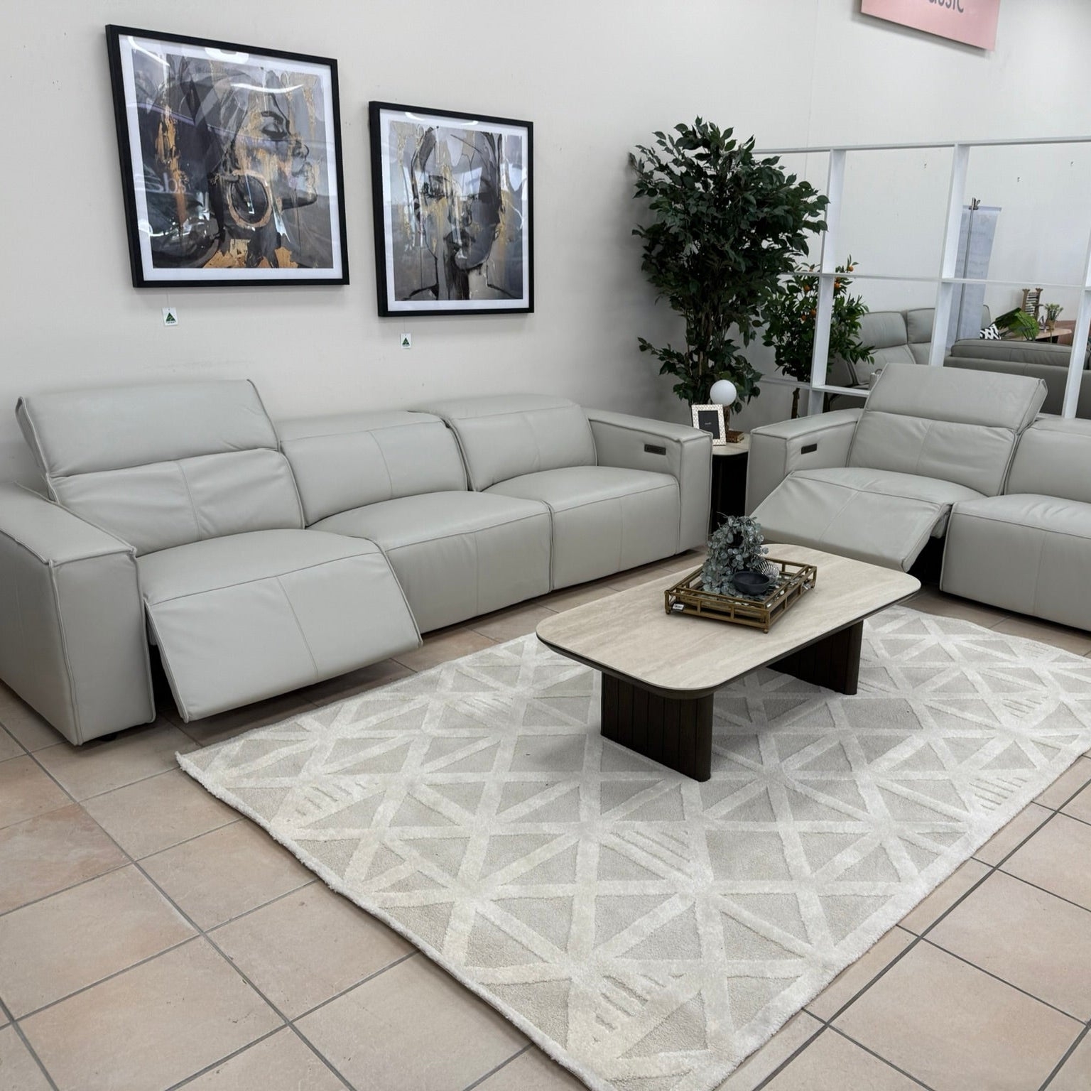 Gray sectional sofa in a showroom with a coffee table and decor items.