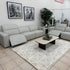Gray sectional sofa in a showroom with a coffee table and decor items.
